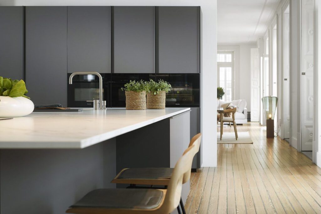 Cocina gris con isla y encimera blanca