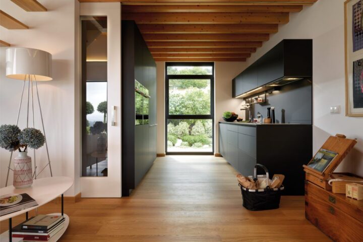 Cocina paralela de pasillo con frentes oscuros y madera