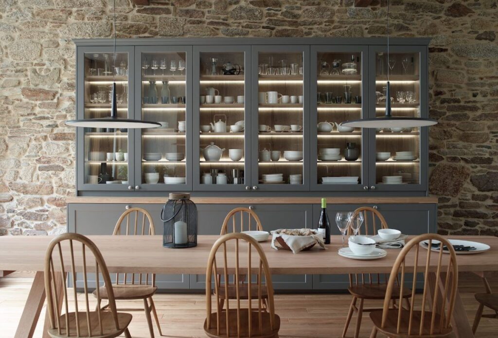 Vitrina de cocina con frentes de cristal y pared de piedra